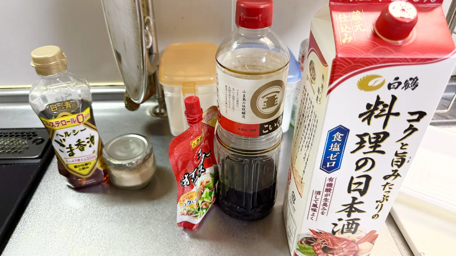 調理に使ったごま油、塩、オイスターソース、醤油、料理酒のボトル